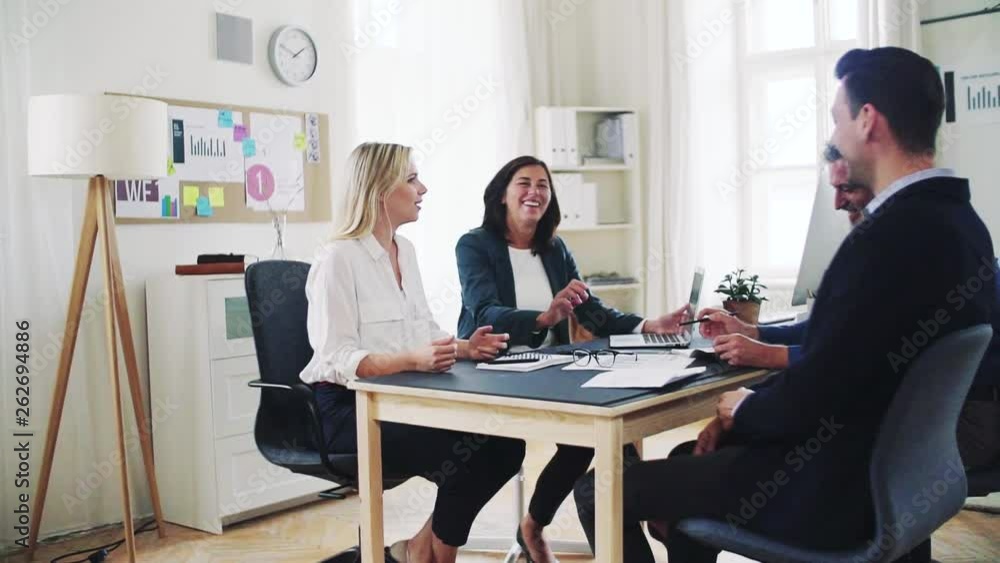 Group of young and old businesspeople with laptop working together in office. Group of young and old businesspeople with laptop working together in office.