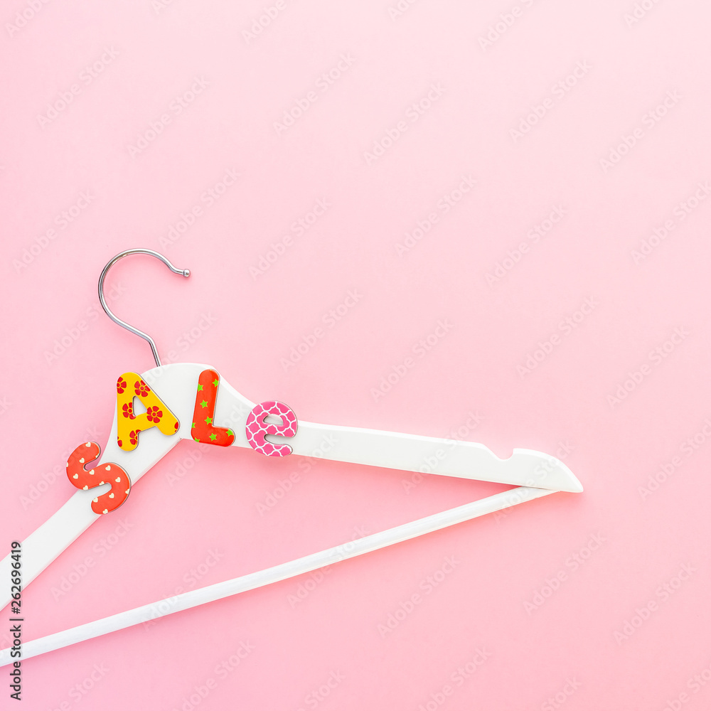 White hangers with sale text on pink background White hangers with sale text on pink background