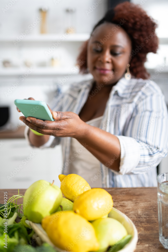 Pleased international housewife using her smartphone for photo Pleased international housewife using her smartphone for photo