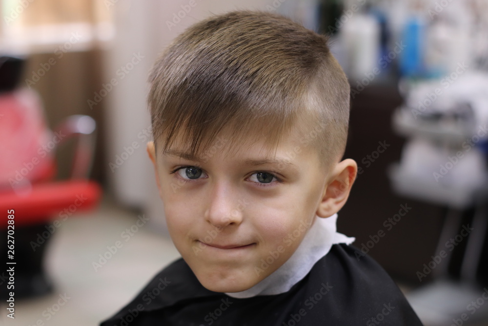 Cute boy model demonstrating hair cut and styling at haidresser'salon Cute boy model demonstrating hair cut and styling at haidresser'salon