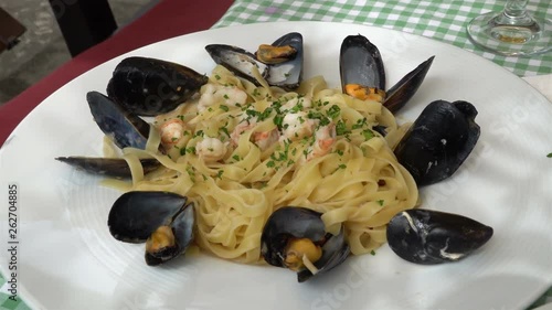 Traditional mediterranean pasta with mussels and seafood on a traditional Medite