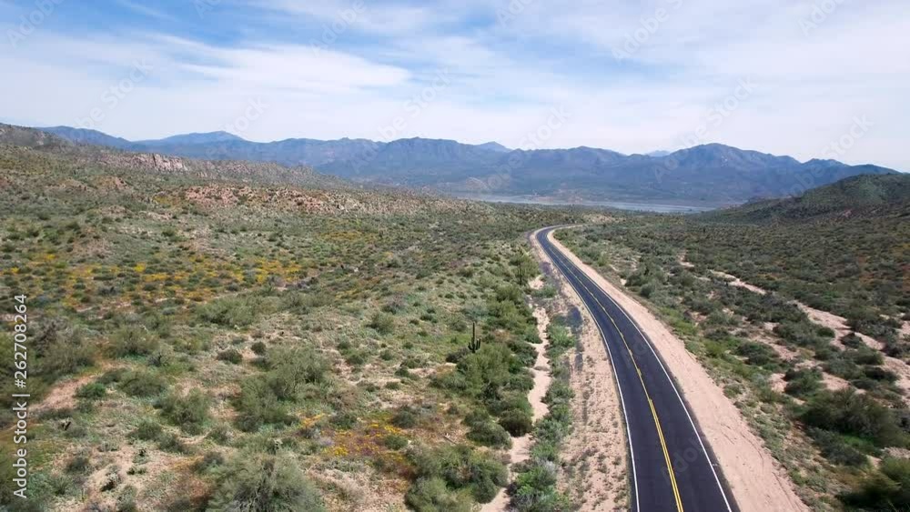 Aerial descend on view of highway leading to Bartlett Lake one black car passes under the drone Tonto National Forest, Sonoran Desert, Bartlett Lake, Arizona. Aerial descend on view of highway leading to Bartlett Lake one black car passes under the drone Tonto National Forest, Sonoran Desert, Bartlett Lake, Arizona.