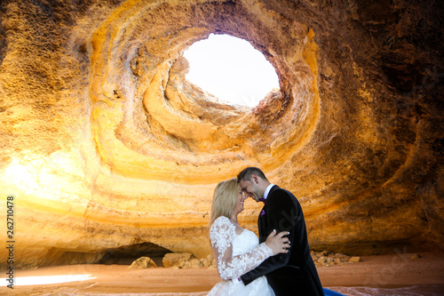 Beautiful wedding couple posing in the caves of Benagil