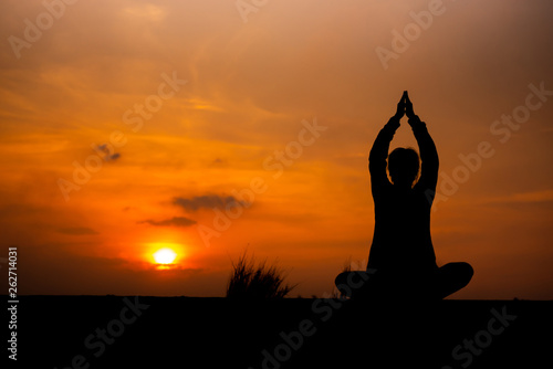 Fototapeta Naklejka Na Ścianę i Meble -  YOGA Silhouette woman sitting area meditating in sunset - Image