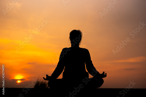 YOGA Silhouette woman sitting area meditating in sunset - Image