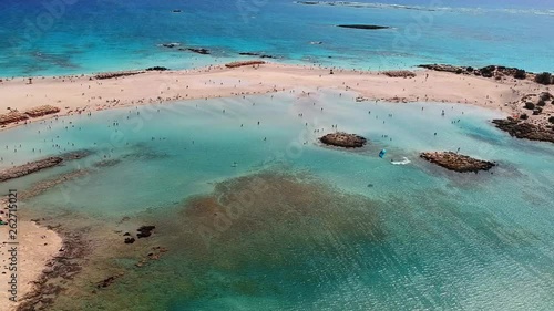 Aerial shot of a surfer paragliding at the amazing white sand beach of Elafonissi in Crete, Greece photo