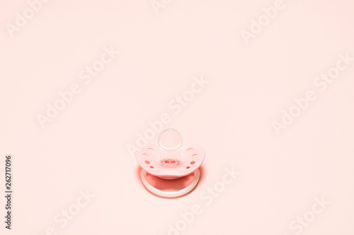 Silicone orthodontic paifier with ventilation holes for newborn baby over pink background. Children newborn concept. Baby girl plastic relax equipment.