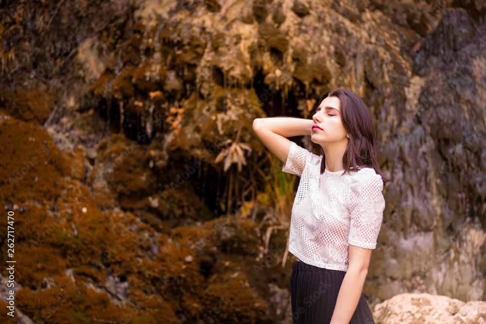 Naklejka premium Beautiful girl posing in river, fairy fast forest in autumn. Beauty, fashion. Spa, healthcare. Tropical vacation. Natural pool.