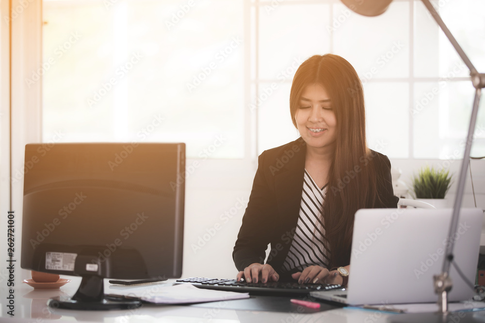 Portrait of a cheerful businesswoman sitting at the table in office . Portrait of a cheerful businesswoman sitting at the table in office .