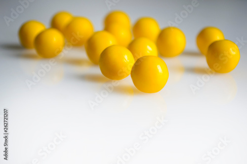 yellow round pills vitamins bada on white table close up