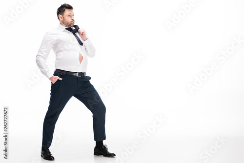 overweight man in tight formal wear posing on white with copy space