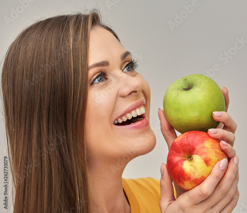 woman smiling with healthy teeth holding two apples. photo