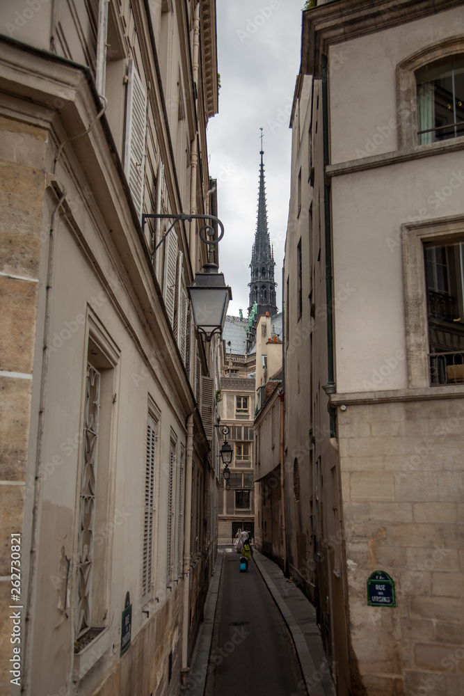 Spire of Notre Dame de Paris Cathedral. Old narrow street in Paris, France, Europe