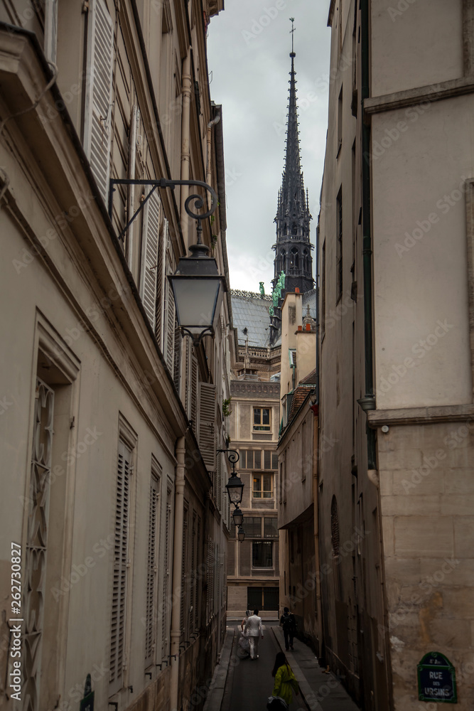 Spire of Notre Dame de Paris Cathedral. Old narrow street in Paris, France, Europe