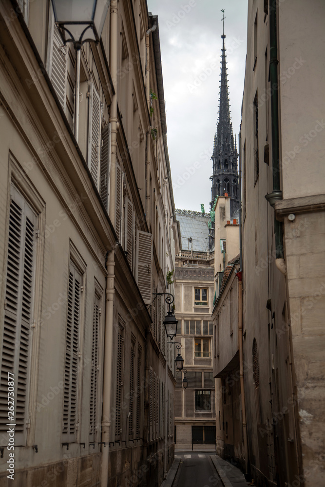 Spire of Notre Dame de Paris Cathedral before fire. Old narrow street in Paris, France, Europe