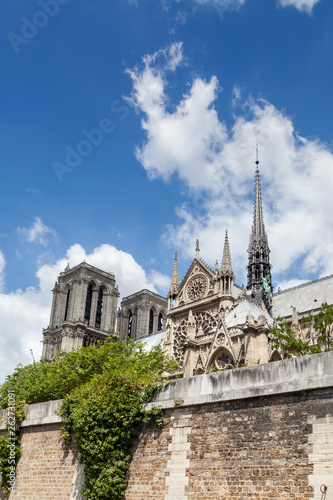 Notre Dame de Paris Cathedral before fire. Southern facade with rose window and a spire on a roof. Sunny summer day