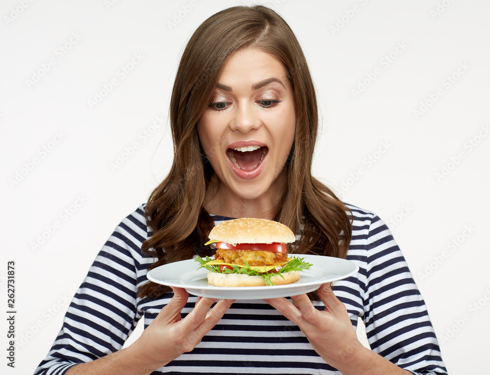 happy woman holding burger on white plate.