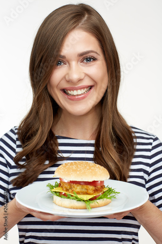 Smiling girl holding white plated with burger.