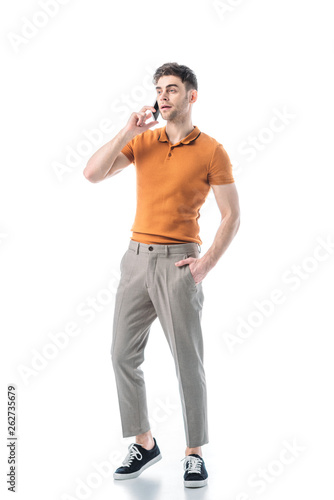 handsome young man with hand in pocket talking on smartphone isolated on white © LIGHTFIELD STUDIOS
