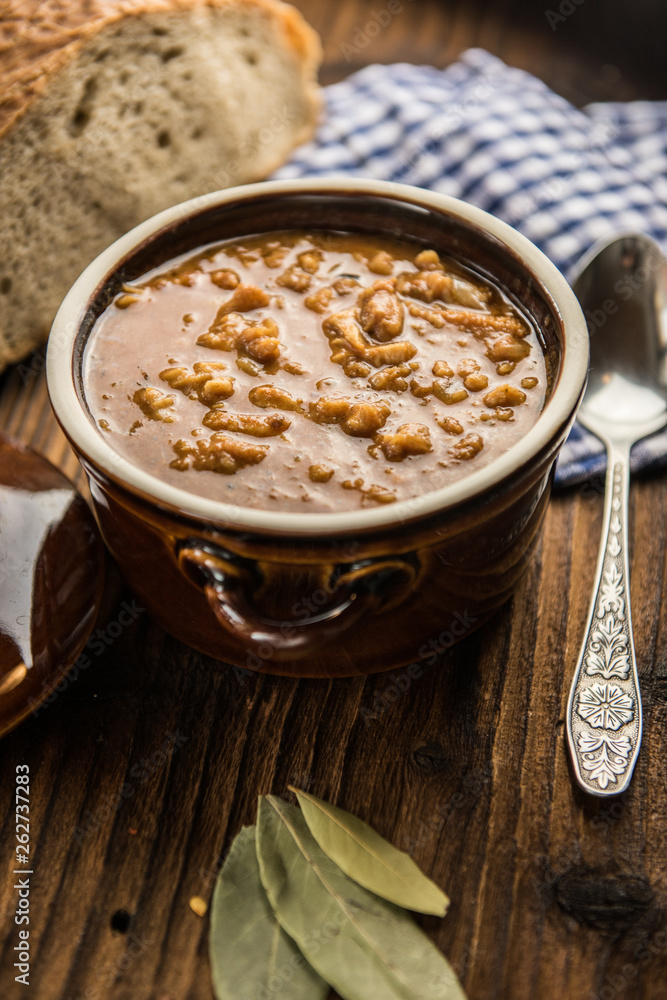 tripe stew sauce in brown ceramic pot on a wood table tripe stew sauce in brown ceramic pot on a wood table