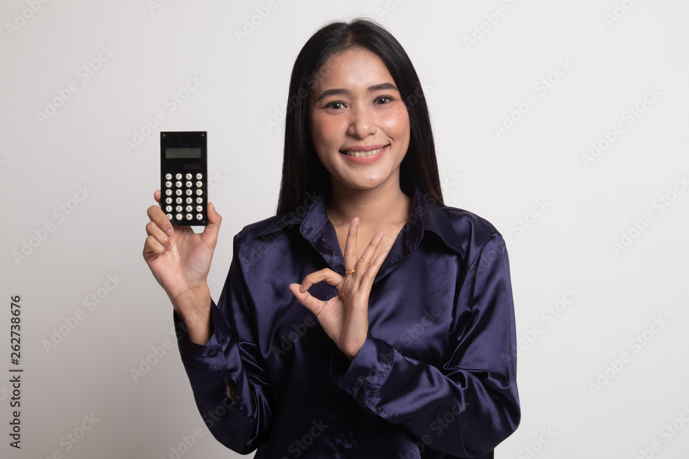 Asian woman show OK with calculator. Asian woman show OK with calculator.