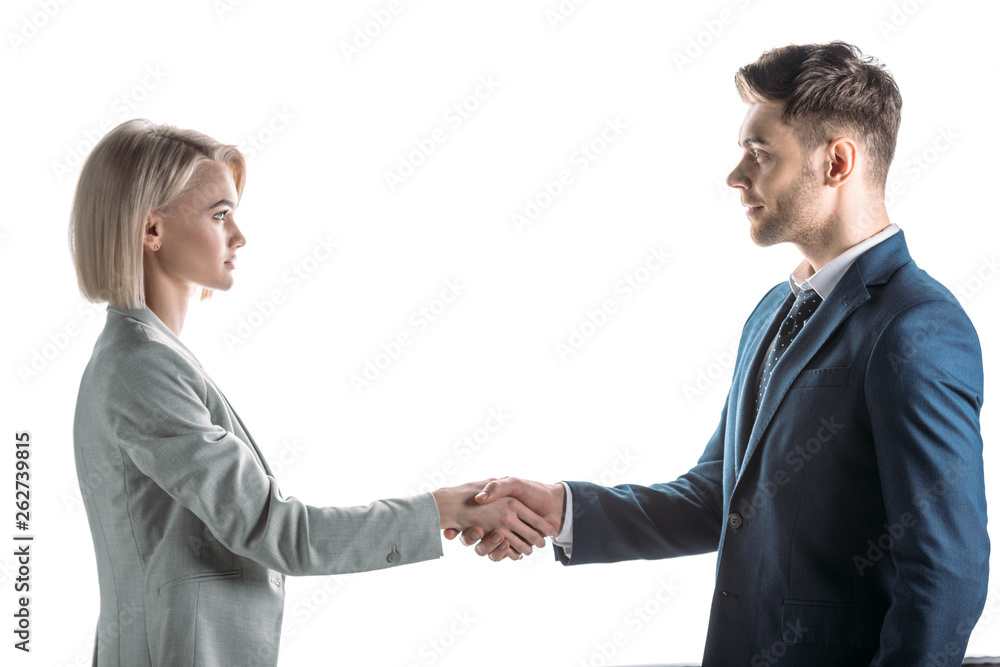 young business partners shaking hands and looking at each other isolated on white young business partners shaking hands and looking at each other isolated on white