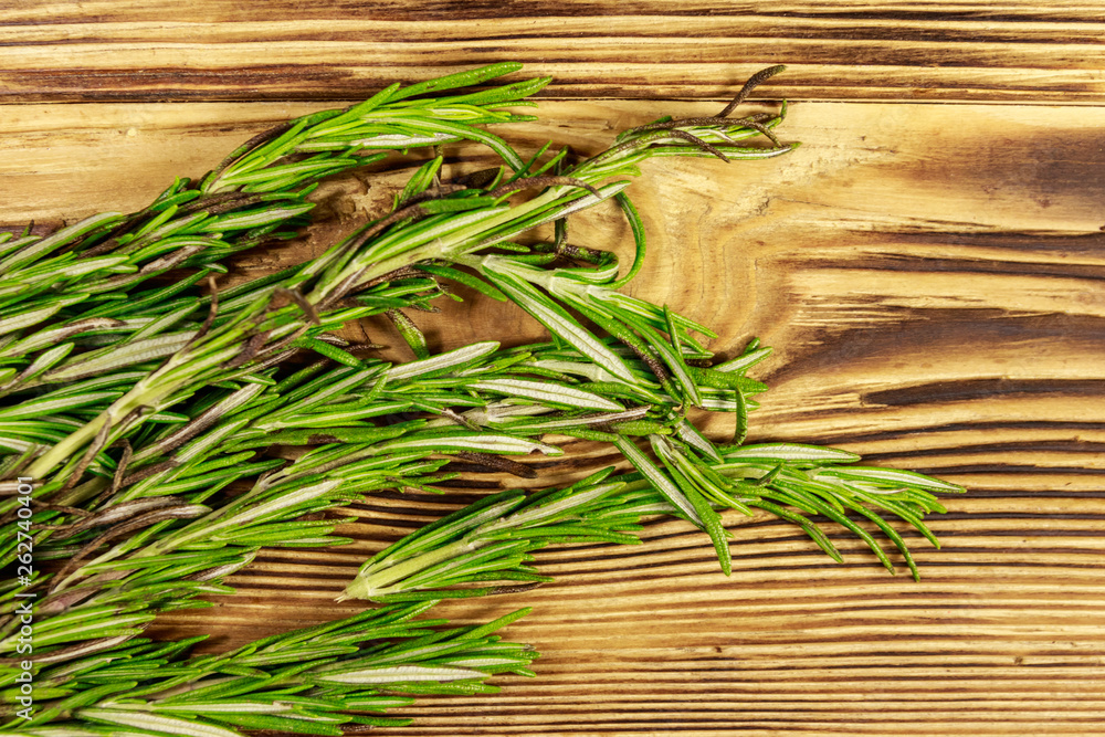 Fresh rosemary herbs on a wooden table. Top view Fresh rosemary herbs on a wooden table. Top view