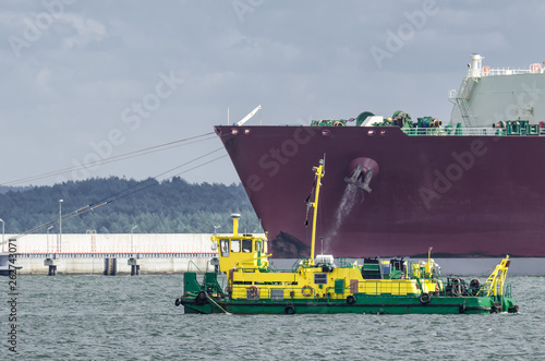 LNG TANKER - Ship moored to the gas terminal and dredger at work photo