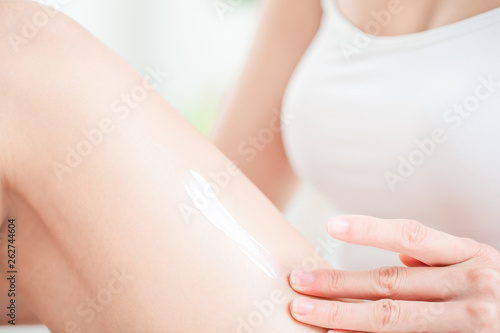 woman applying cream on legs
