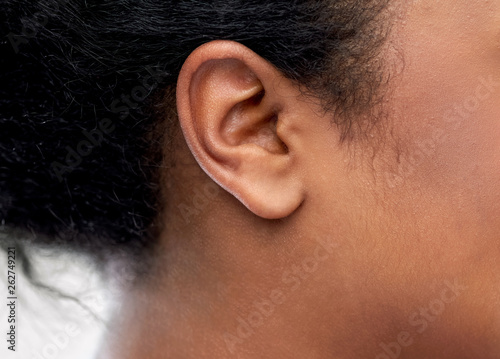 health, people and hearing concept - close up of young african american woman ear photo