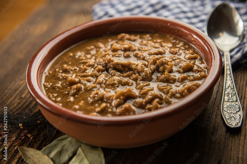 tripe stew sauce in brown ceramic pot on a wood table tripe stew sauce in brown ceramic pot on a wood table