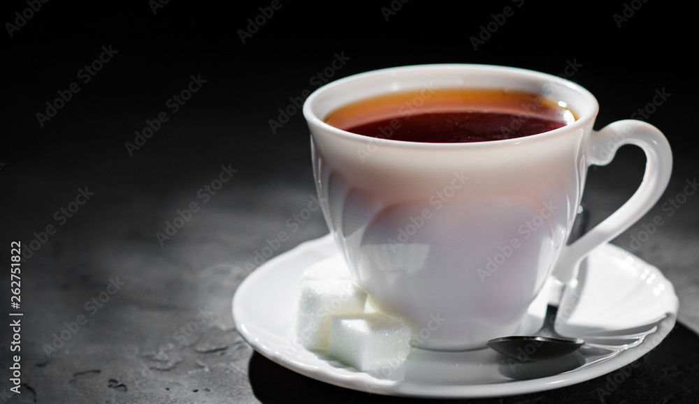 The white cup with black tea on Dark grey black slate background. Copy space.