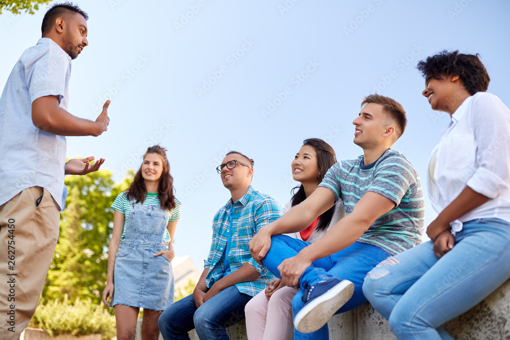 people, friendship and communication concept - group of happy international friends talking in city people, friendship and communication concept - group of happy international friends talking in city