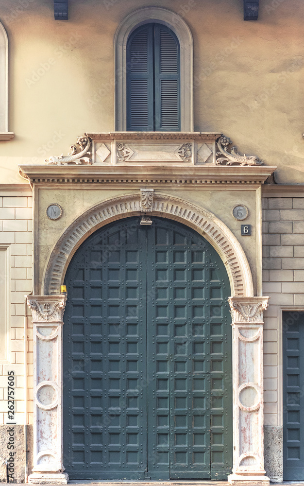 Obraz premium milan - italy, a luxurious marble entrance to an elegant building with a carved wooden door