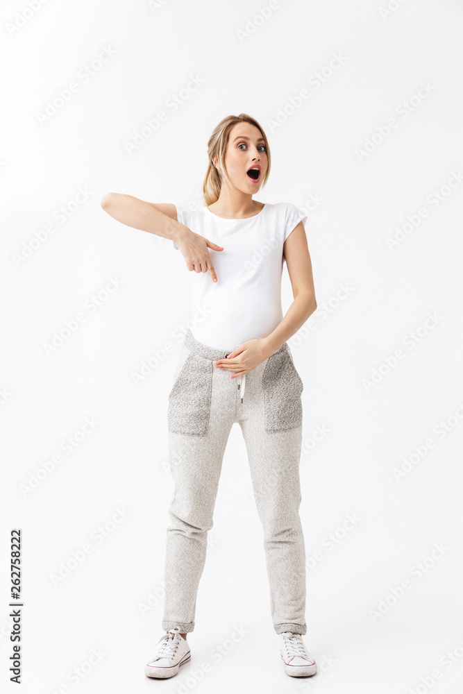 Beautiful young pregnant woman posing isolated over white wall background. Beautiful young pregnant woman posing isolated over white wall background.