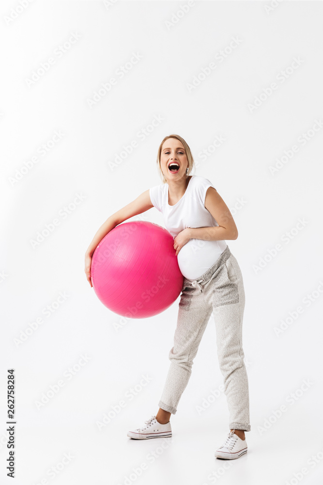 Beautiful young pregnant yoga fitness woman posing isolated over white wall background make exercises with ball. Beautiful young pregnant yoga fitness woman posing isolated over white wall background make exercises with ball.