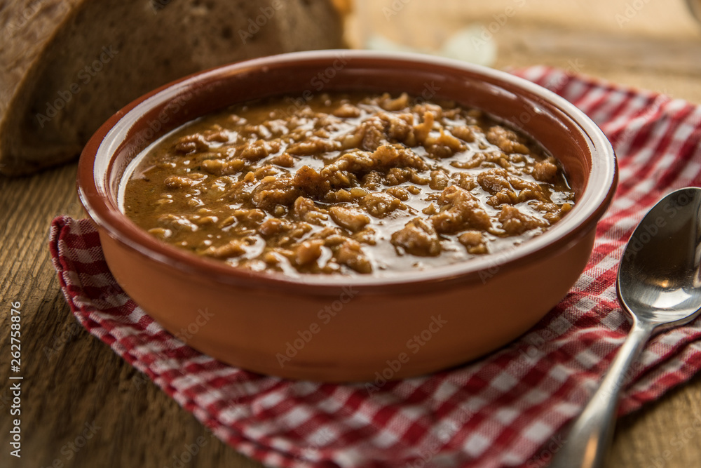 tripe stew sauce in brown ceramic pot on a wood table tripe stew sauce in brown ceramic pot on a wood table