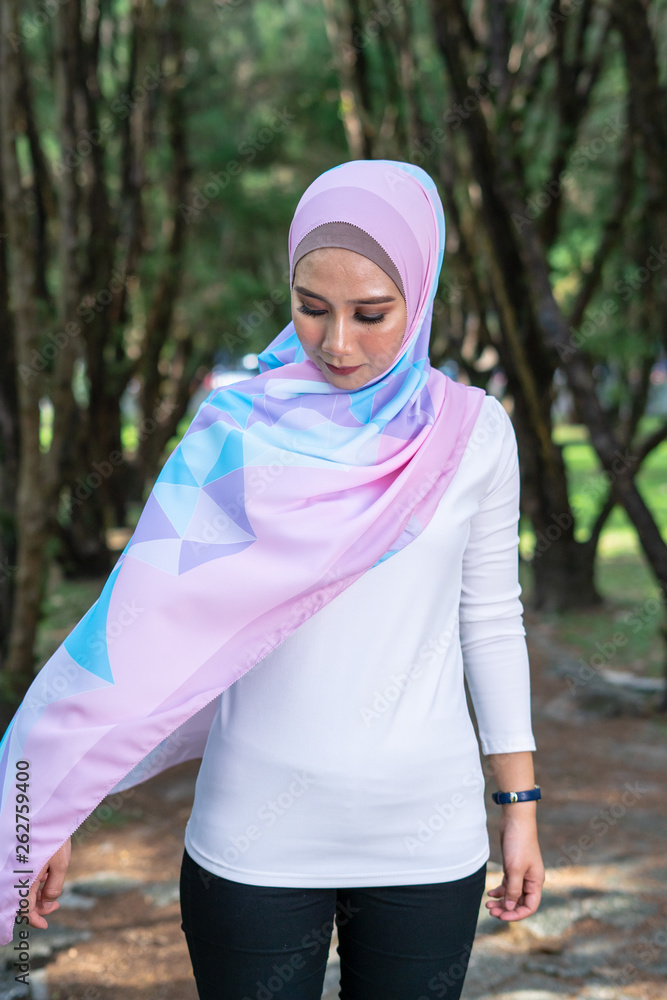 Portrait of lovely young Malay woman, modern stylish Muslim fashion, nature background. Selective focus. Portrait of lovely young Malay woman, modern stylish Muslim fashion, nature background. Selective focus.