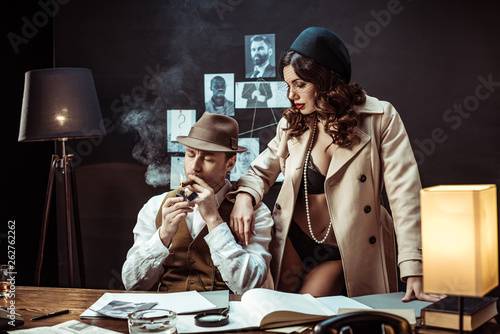 Sexy woman in underwear and trench coat seducing detective in office