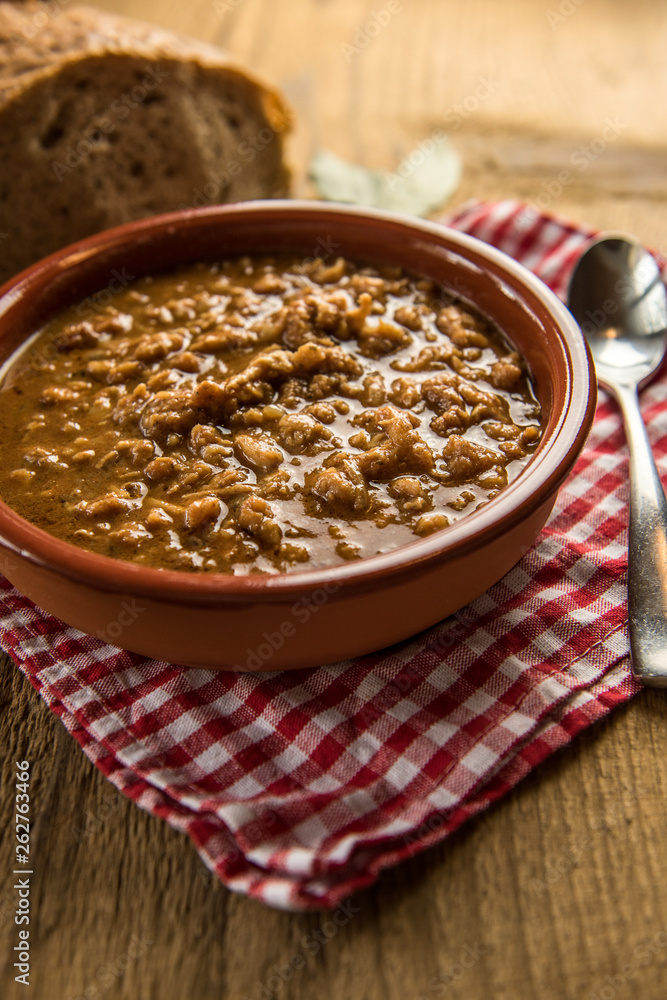 tripe stew sauce in brown ceramic pot on a wood table tripe stew sauce in brown ceramic pot on a wood table