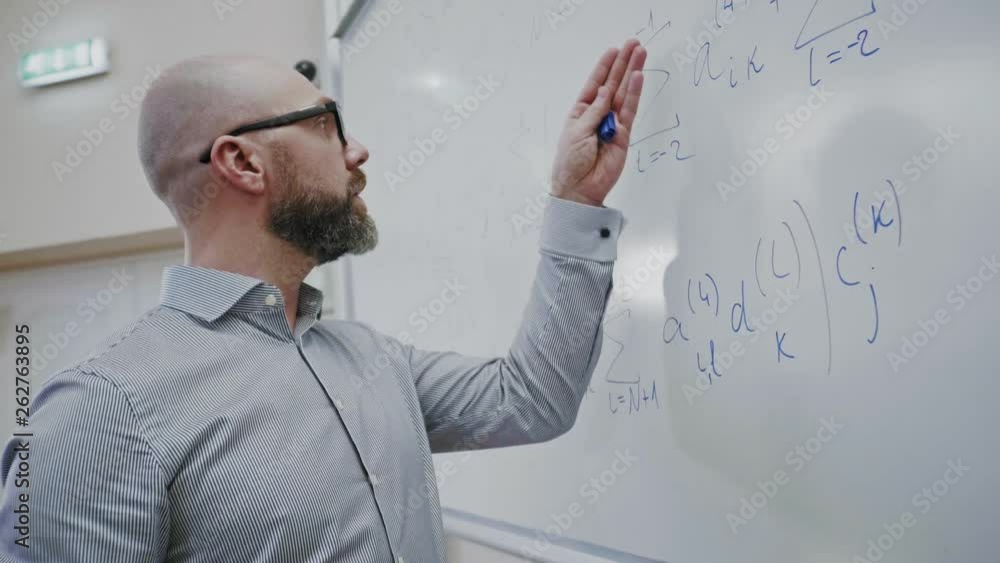 Lecturer writing formula on a board Lecturer writing formula on a board