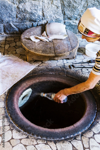 Typical armenian bread (lavash) cooking inside the huge ceramic jar.