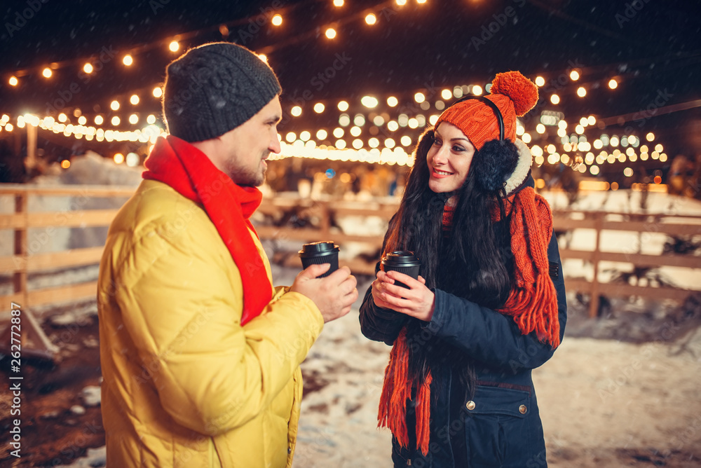 Winter evening, love couple drinks coffee outdoors