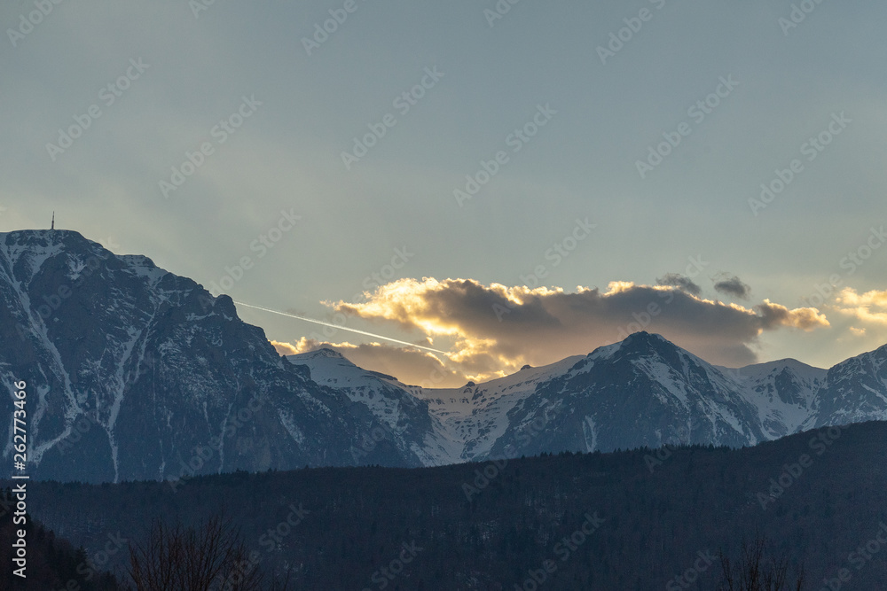 Dramatic clouds over mountains, at sunset time