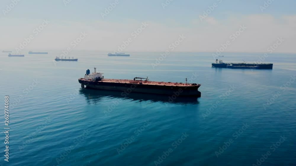 Oil tanker waiting in local harbour to be unloaded surrounded with calm blue sea Oil tanker waiting in local harbour to be unloaded surrounded with calm blue sea
