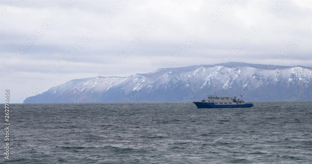 Glum cloudy sky Baikal lake wave and ship surfing on the water in Listvyanka, Russia Glum cloudy sky Baikal lake wave and ship surfing on the water in Listvyanka, Russia