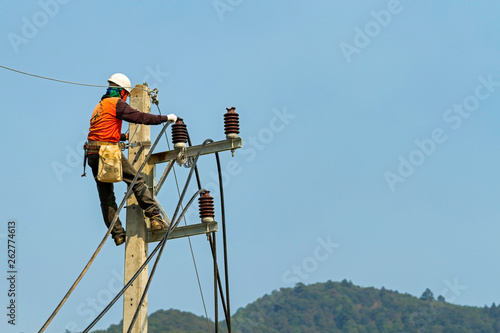Electrician man on electric pole to install new electric cable