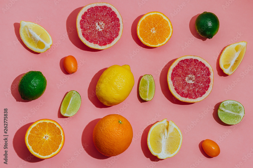 tropical and citrus fruit sliced over light pink background. Pastel style. top view. space for text. tropical and citrus fruit sliced over light pink background. Pastel style. top view. space for text.