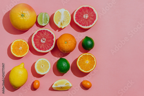 tropical and  citrus fruit sliced  over light pink background. Pastel style. top view. space for text.