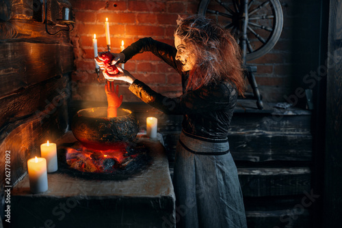 Scary witch cooking soup with human body parts